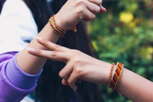 A sister ties a rakhi on her brother's wrist during Raksha Bandhan gifting ceremonies in India