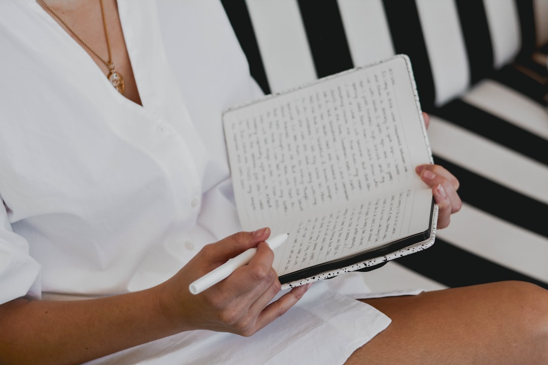 A traveler writes in a handmade journal at an Indian craft market, surrounded by traditional paper and binding materials.