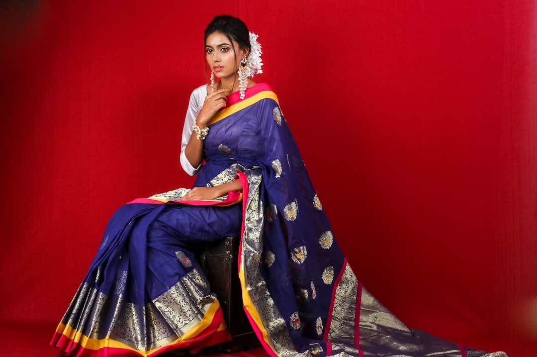 An Indian bride draped in handwoven silk sarees with golden zari embroidery at a wedding ceremony