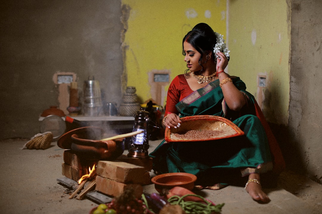 A South Asian chef stirs a pot of tamarind broth in a Southeast Asian kitchen, capturing the essence of monsoon flavours
