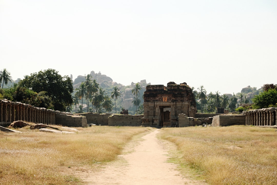 A group of visitors walks along the crumbling ramparts of a Deccan forts site in southern India