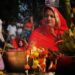 A woman devotee taking part in Janmashtami celebrations at a lit temple in Mathura at midnight