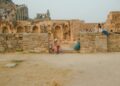 woman-exploring-ancient-fort-india-unsplash - INDIAwebzine A solo female traveler stands inside the stone gateway of one of the lesser-known Deccan forts in Karnataka