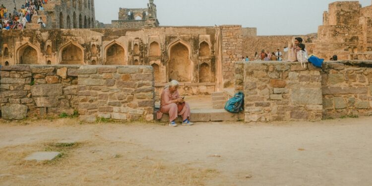 A solo female traveler stands inside the stone gateway of one of the lesser-known Deccan forts in Karnataka