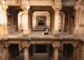 woman-exploring-stepwell-india-unsplash - INDIAwebzine A woman descends the intricate stone steps of one of India's ancient stepwells in Rajasthan in golden morning light