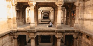 woman-exploring-stepwell-india-unsplash - INDIAwebzine A woman descends the intricate stone steps of one of India's ancient stepwells in Rajasthan in golden morning light
