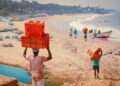 A woman selecting fresh fish at a bustling Indian coastal market, representing the heart of coastal cuisine traditions