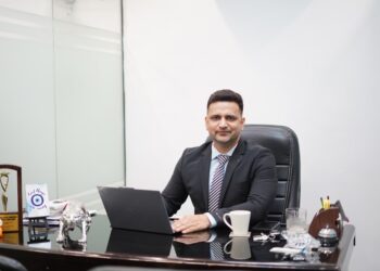 A focused Indian professional reviews REITs in India unit statements at a modern office desk