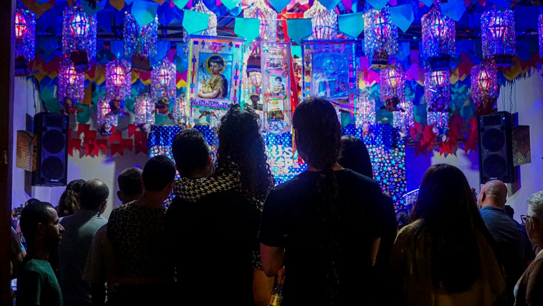Diaspora community members in colourful dress join Navratri celebrations at a decorated community hall abroad