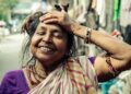 A young Indian woman applying ubtan paste to her face as part of her traditional skincare ritual