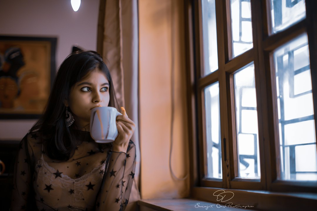 A woman holding a warm cup of herbal ginger tea as part of a daily Ayurvedic detox cleanse routine