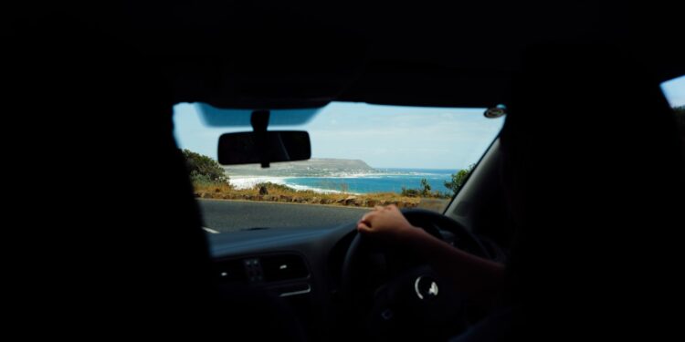 traveller-driving-open-coastal-road-unsplash - INDIAwebzine A traveller on the wheel enjoying coastal drives in India with green hills and the Arabian Sea visible through the windscreen