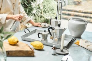 A woman in an Indian kitchen assembling a zero-chemical cleaning kit with lemon, baking soda, and vinegar on the counter