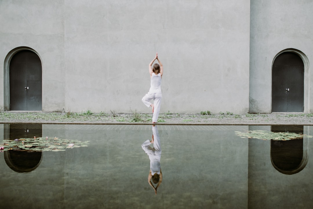 A woman practises morning yoga on a wooden deck overlooking the backwaters at one of Kerala's top Ayurvedic heritage retreats