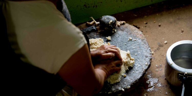 Woman preparing fermented foods batter in an Indian kitchen