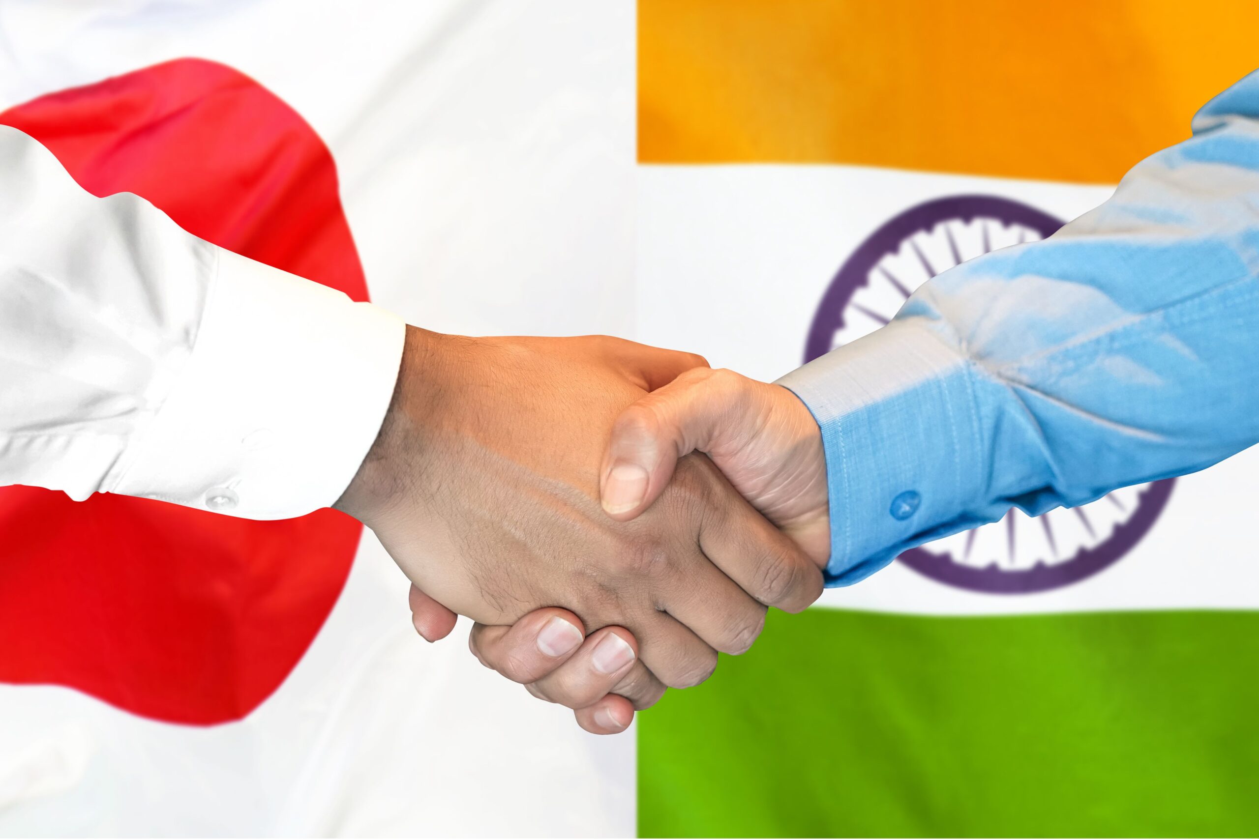 Apretón de manos de asociación Japón-India con banderas nacionales que representan la cooperación tecnológica y la colaboración en inversiones