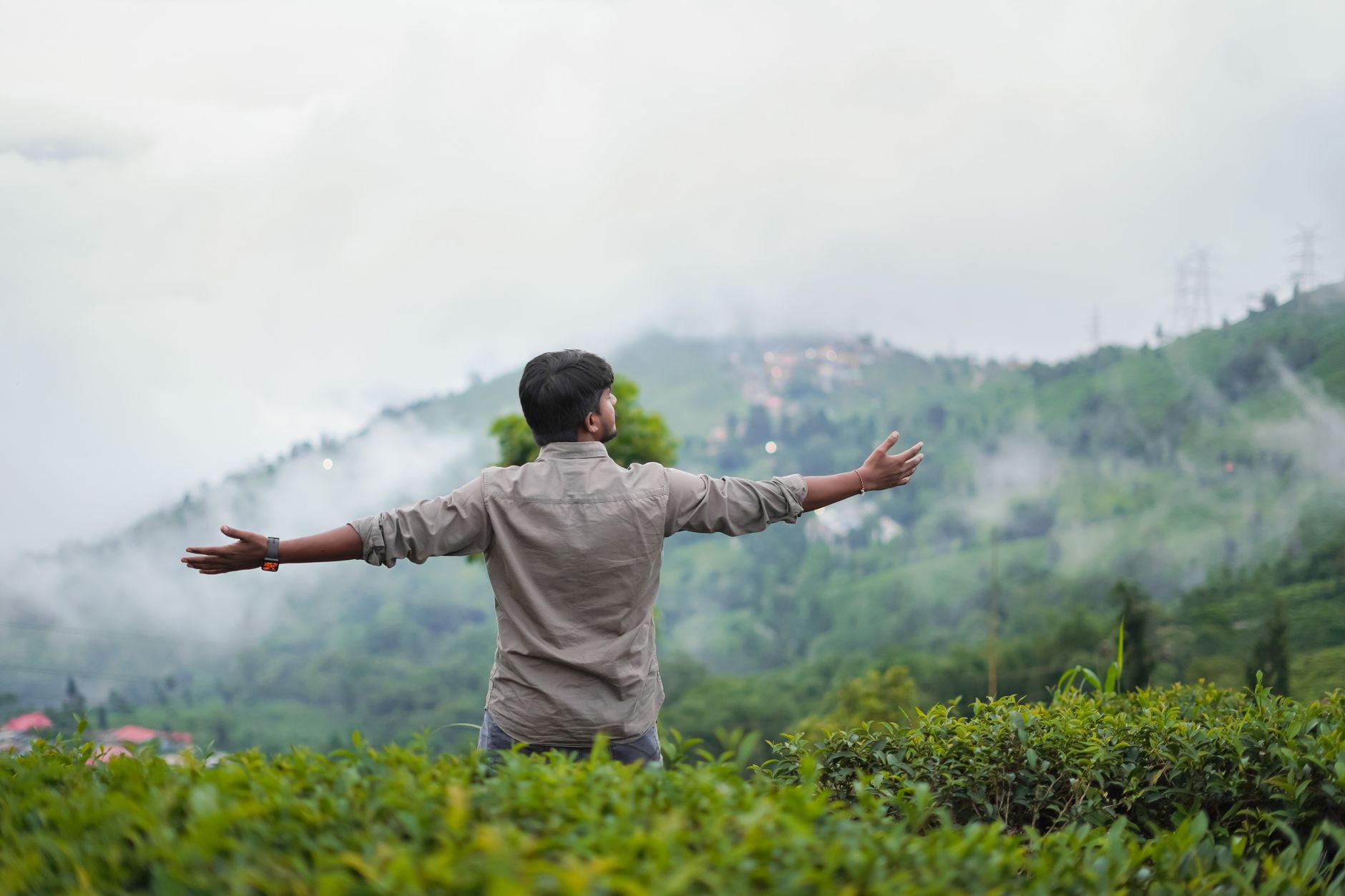 Un viajero caminando a través de brumosas plantaciones de té en Kerala durante la temporada de monzones en India