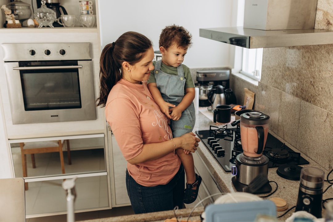 Una madre y su hijo realizando experimentos científicos en casa usando cúrcuma y tazones en una encimera de cocina en India