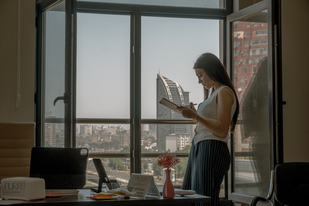Una mujer profesional india enfocada revisando los documentos de inversión de su cuenta NPS nivel II en un escritorio