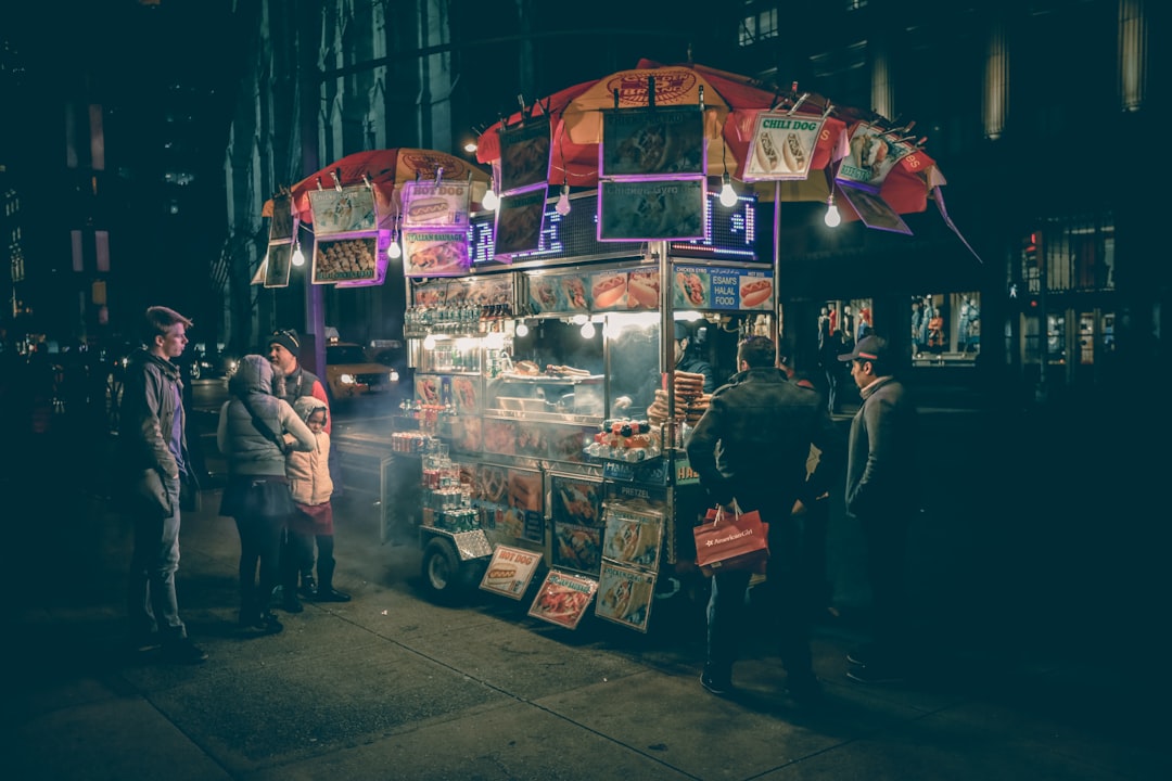 Un vendeur de rue souriant frit des pakoras dorés à un étal achalandé, capturant la joie de la cuisine de rue en mousson à Delhi
