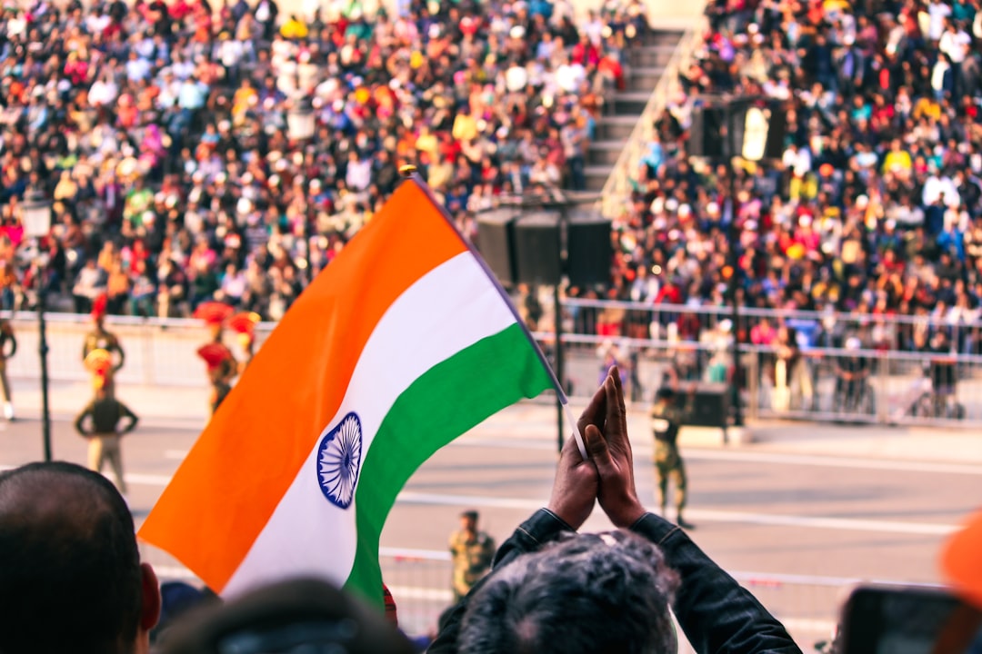 Una mujer con vestimenta tradicional sostiene la bandera tricolor india en una ceremonia de celebración del Día de la Independencia de la diáspora india en el extranjero.