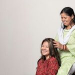 Una mujer realizando un masaje tradicional de cuidado del cuero cabelludo con aceite en su largo cabello oscuro indio en casa
