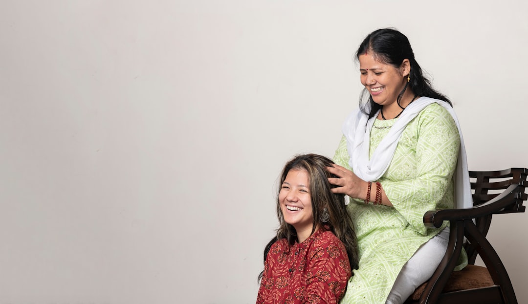 Una mujer realizando un masaje tradicional de cuidado del cuero cabelludo con aceite en su largo cabello oscuro indio en casa