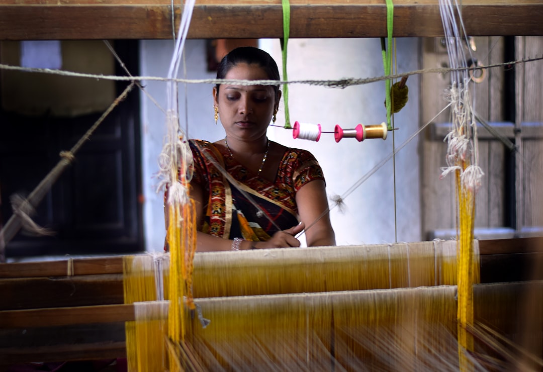 Une artisane expérimentée tissant des saris en soie tissée à la main sur un métier à tisser traditionnel en Inde
