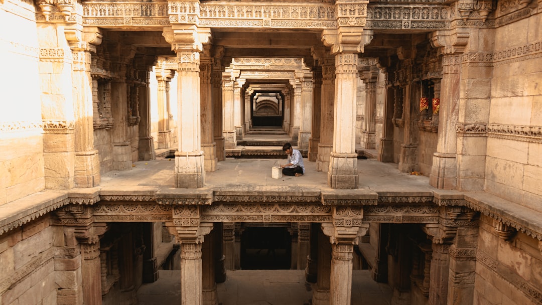 Una mujer desciende los intrincados escalones de piedra de uno de los antiguos pozos escalonados de India en Rajasthan con la luz dorada de la mañana