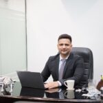 Un profesional indio enfocado revisa los estados de unidades de REIT en India en un escritorio de oficina moderno
