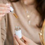 Una mujer masajeando aceite de kumkumadi en su piel durante un ritual nocturno de cuidado de la piel ayurvédico