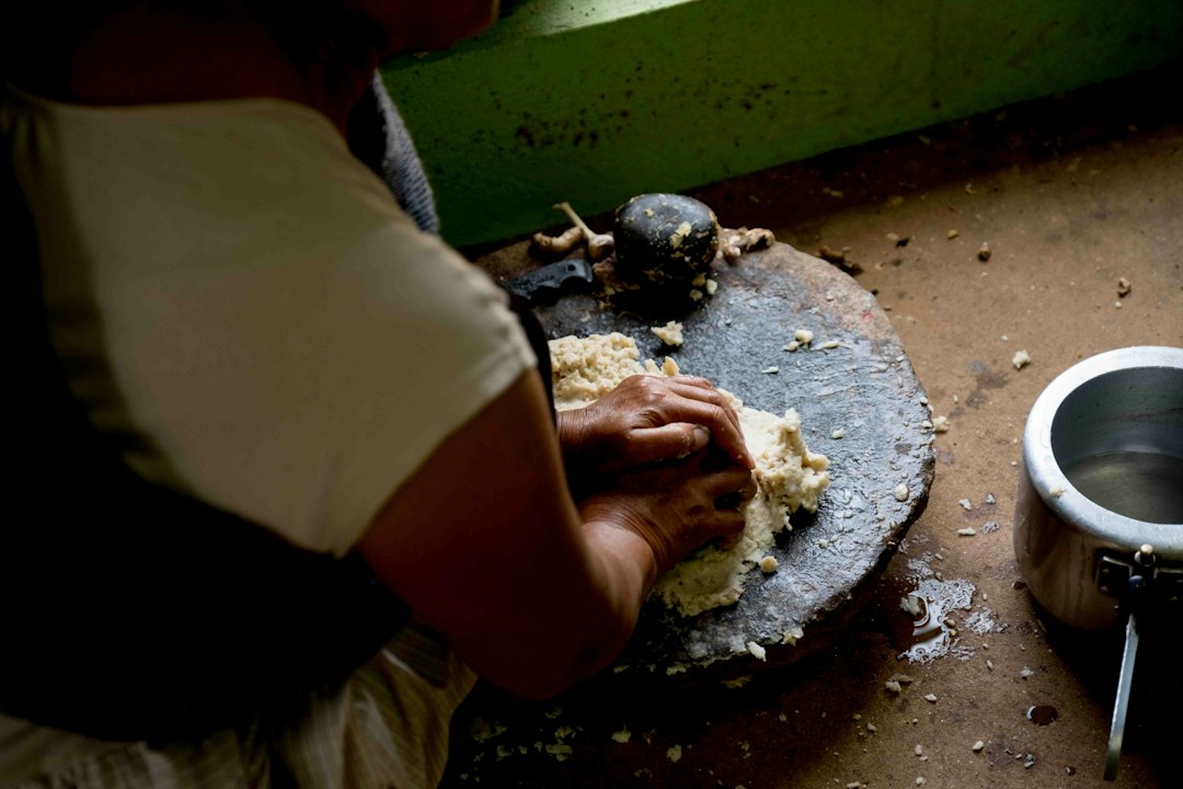 Mujer preparando masa para alimentos fermentados en una cocina india