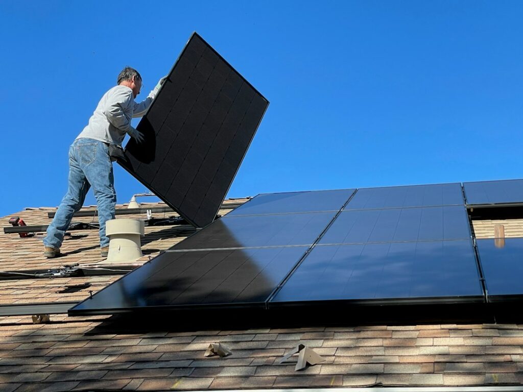 Propietario inspeccionando la instalación de paneles solares en el techo de una casa india